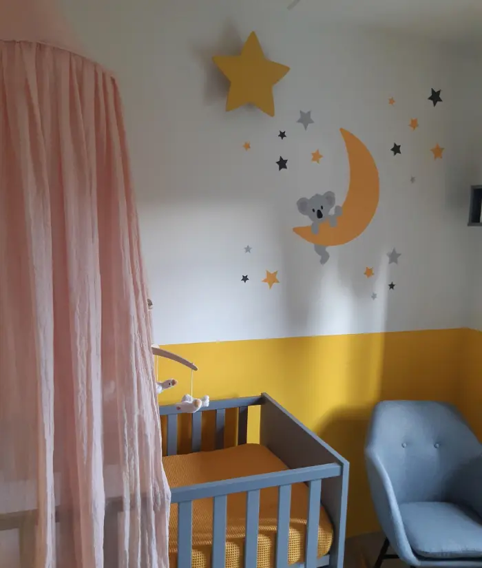 Okergele babykamer met een hangende koalabeer op de maan
